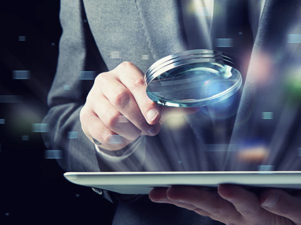 Businessman examines a tablet with a magnifying glass. Concept of internet security Businessman examines an infected tablet with a magnifying glass. Concept of internet security